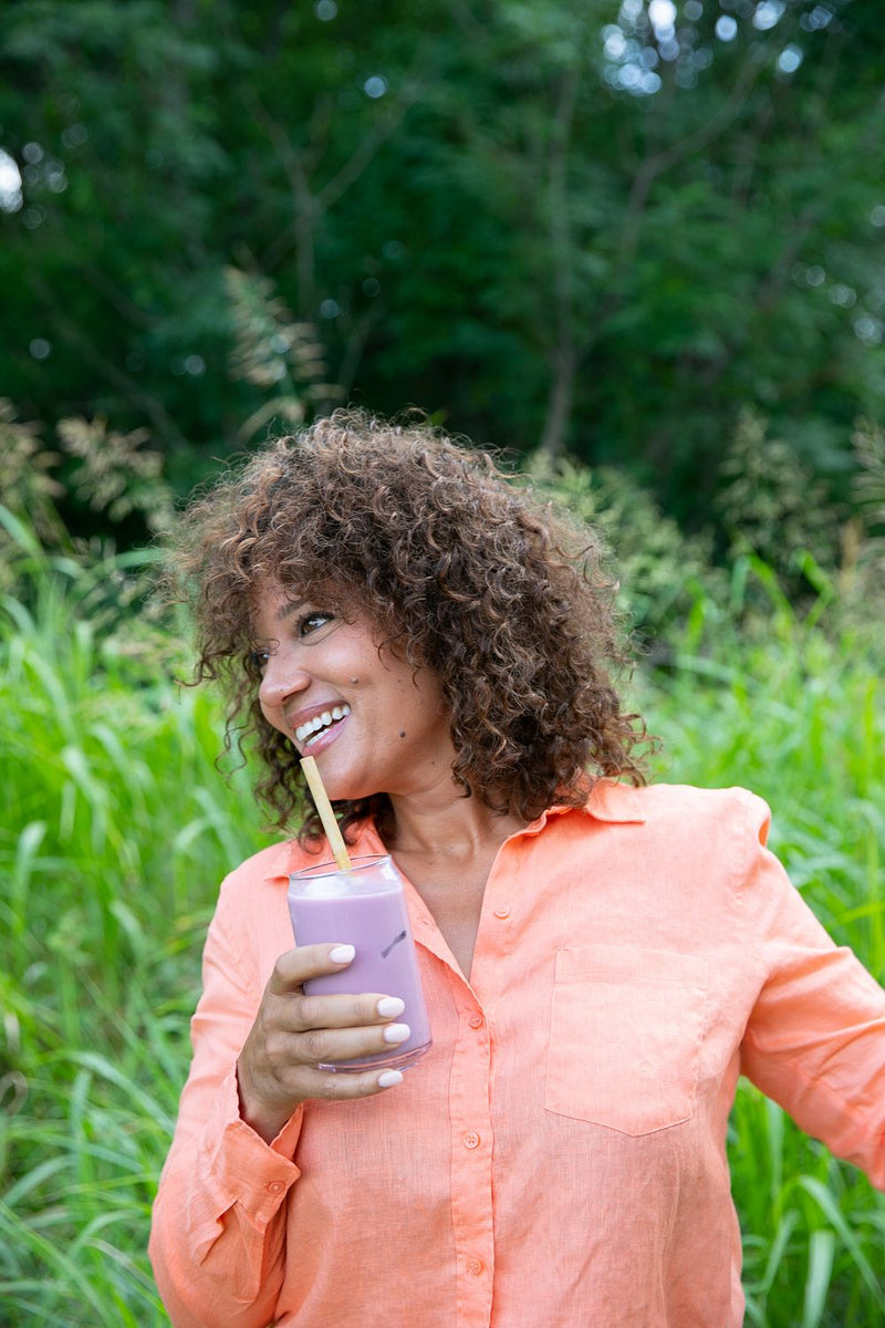 Woman enjoying a Your Super smoothie in a park